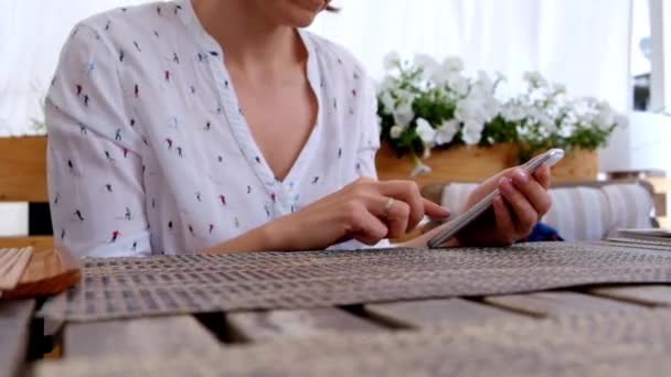 Vrouwelijke Hand Holding Smartphone, in een café of restaurant — Stockvideo