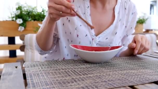 Жінка їсть рис з овочами в азіатському ресторані, крупним планом — стокове відео