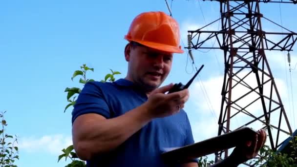 Elektroingenjör arbetar. Pratar i telefon och arbetar på tabletten. — Stockvideo