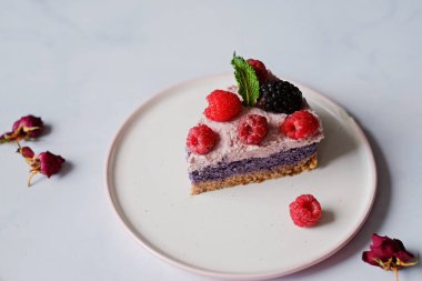Çiğ vegan kek ahududu ve bluberries beyaz masada