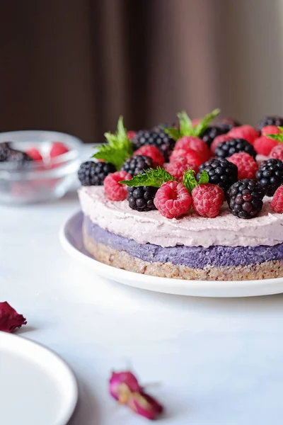Çiğ vegan kek ahududu ve bluberries beyaz masada