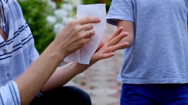 Детская гигиена. Женщина чистит детские руки влажной салфеткой — стоковое видео