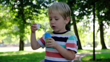 Sevimli çocuk yaz arka plan açık havada, sabun köpüğü üfleme. Çocukluk kavramı.