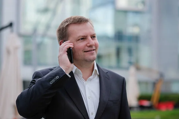 Uomo d'affari fiducioso di mezza età, che parla al telefono, fuori — Foto Stock