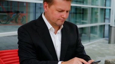 Akıllı telefon, dışarıda tutarak kendine güvenen genç işadamı