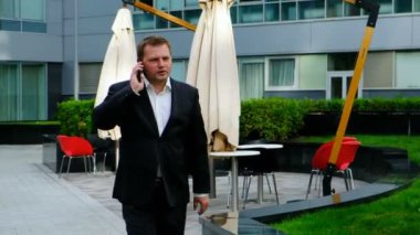 Dışında da telefonda konuşurken kendine güvenen genç işadamı