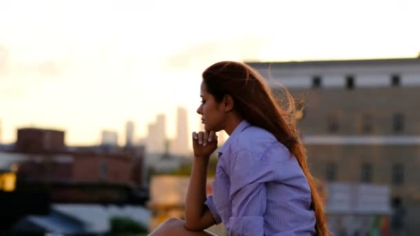 Gyönyörű nő, hosszú haj, ül a tetőn. Magány koncepció. — Stock videók