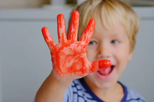 Happy three years old boy painting finger paints