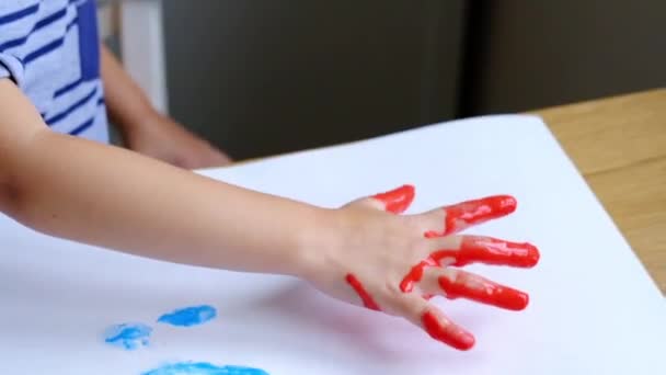 Malý chlapec prstem maluje s radostí — Stock video