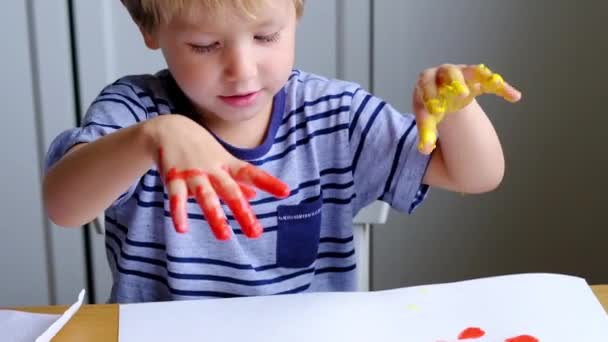 Malý chlapec prstem maluje s radostí — Stock video
