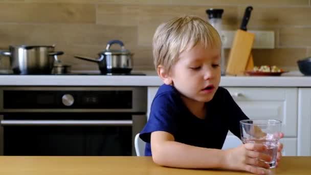 Niño bebiendo agua en la cocina — Vídeos de Stock