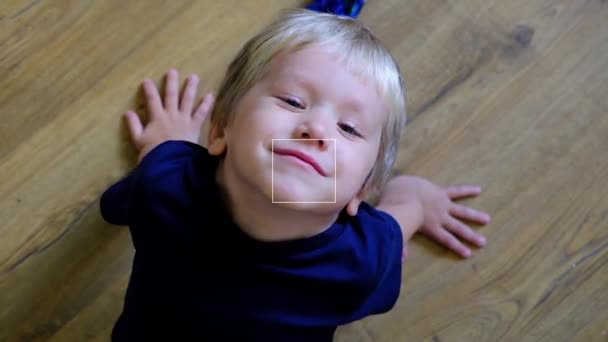 Niño mirando a la cámara y sonriendo, vista superior — Vídeo de stock