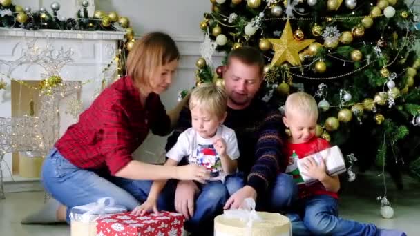 Familia feliz con regalos en el árbol de Navidad — Vídeo de stock