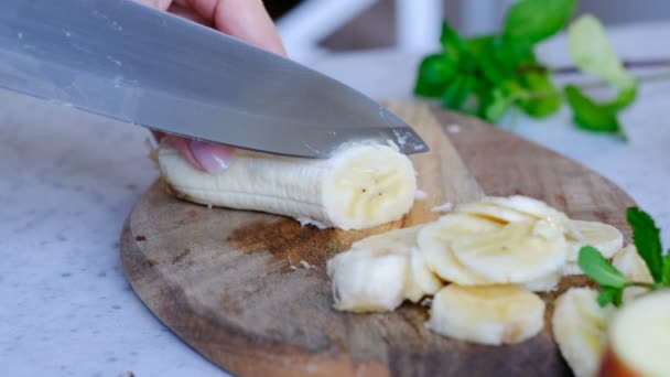 Frau schneidet Banane, aus nächster Nähe — Stockvideo