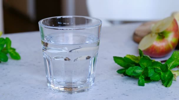 Кто-то добавил хлорофилл в стакан воды — стоковое видео
