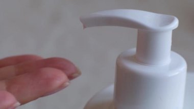 Banyo temiz elinde krem şişesi üzerinde parmak basma düğmesi. Cilt Bakımı, hijyen ve sağlıklı yaşam konsepti. Yakın çekim