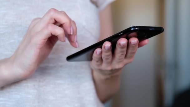 Femme avec téléphone portable moderne dans les mains écran tactile. Intérieur de bureau flou sur fond . — Video