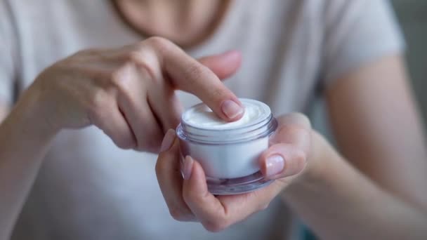 Hudvård för ansiktet. Närbild av kvinnliga händerna applicera kräm, Lotion. Skönhet och kropp vård koncept — Stockvideo