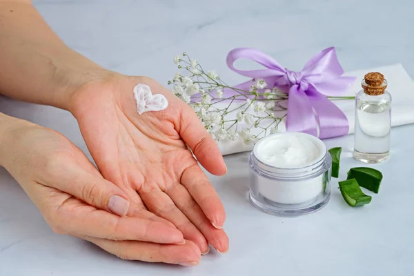 Spa produtos naturais de cuidados da pele com as mãos das mulheres e coração pintado, creme de aloe vera e óleo sobre fundo branco — Fotografia de Stock