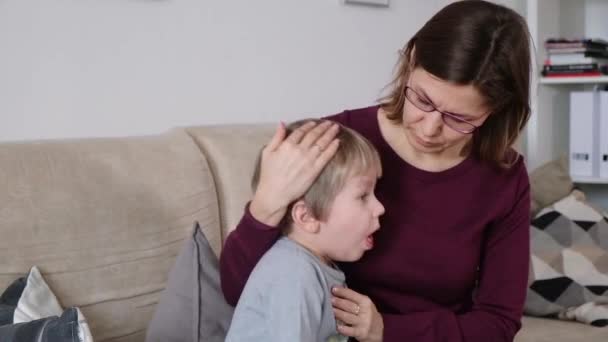 Lindo niño está tosiendo, sentado con su madre en una sala de estar — Vídeos de Stock