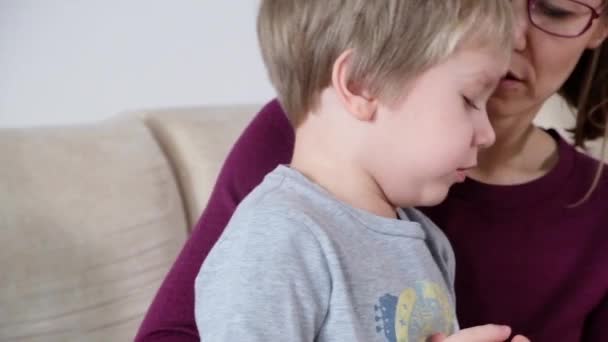 Sevimli küçük çocuk öksürük, annesiyle birlikte oturma odasında oturup — Stok video