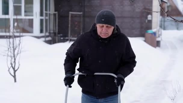 Winter and cleaning concept - mature man shoveling snow from driveway — Stock Video