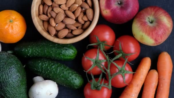 Concepto de comida vegana cruda saludable. Frutas y hortalizas sobre fondo negro . — Vídeo de stock