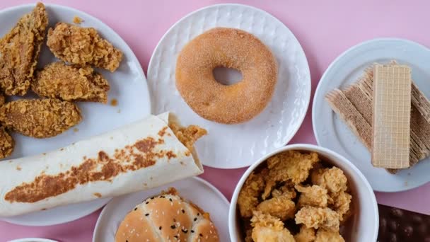 Konzeptaufnahme von gesunder und ungesunder Ernährung. Obst und Gemüse gegen Fast Food. Blick von oben, flache Lage — Stockvideo