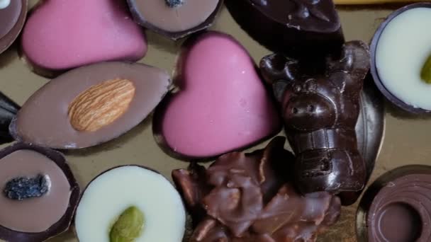 Cioccolato assortito e cacao su sfondo nero, da vicino. Direttamente sopra la vista — Video Stock