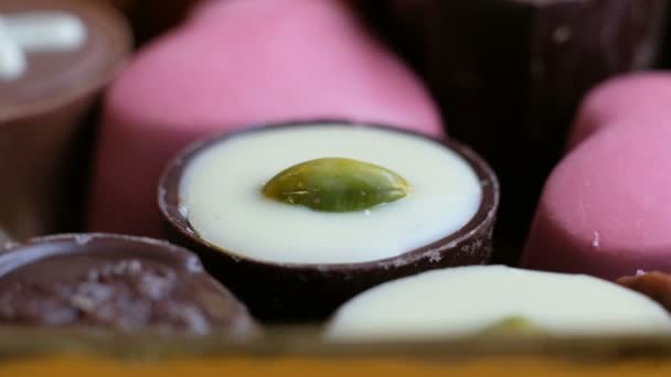 Frau wählt verschiedene Schokolade aus Schachtel leckeren Desserthintergrund. Makro, Nahaufnahme — Stockvideo