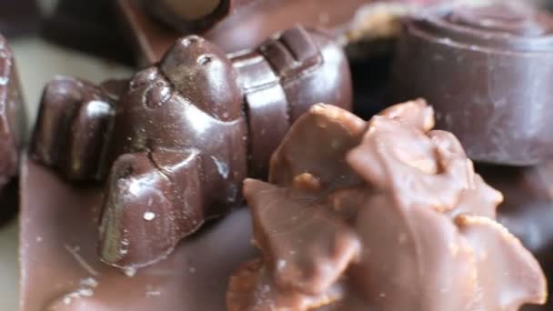 Chocolate variado e cacau no fundo preto, de perto. Vista de ângulo alto — Vídeo de Stock