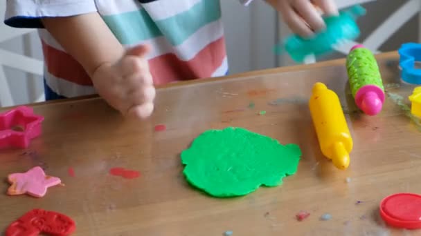 Piękny 4 lat chłopiec z playdough w domu. Ręce z bliska — Wideo stockowe