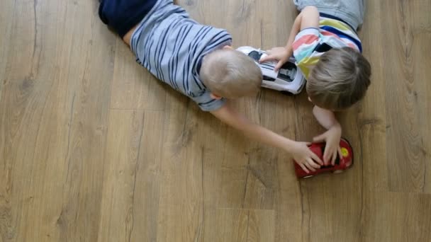 Concepto familiar. Chicos jugando con coches en el suelo de madera. Directamente encima de la vista — Vídeos de Stock