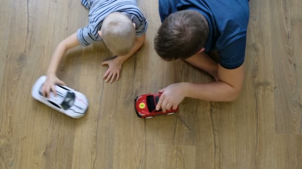 Family concept. Boy and dad playing with cars on wooden floor. Father with son. Directly above view — Stock Video