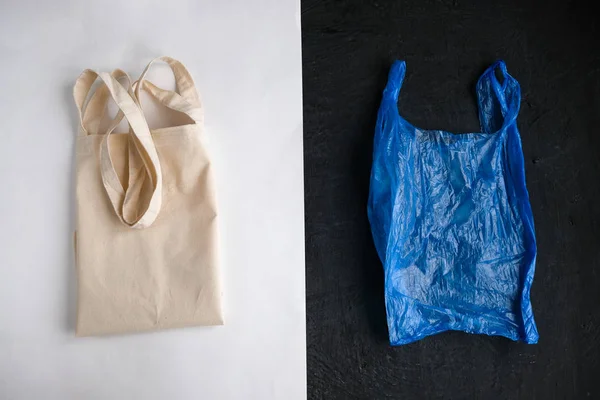 Plastic free concept. Cotton bag and plastic bag on white and black background. Flat lay