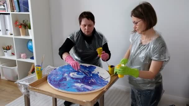 Жінки роблять рідку художню акрилову картину. Креативний космічний художній хіпі шпалери в синьому кольорі з руками творця . — стокове відео