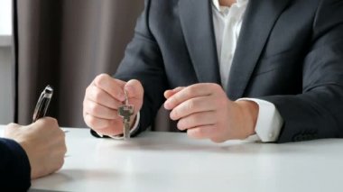 Emlak komisyoncusu ve müşteri bir sözleşme imzaladıktan sonra el sallayarak: gayrimenkul, ev kredisi kavramı. Yakın çekim