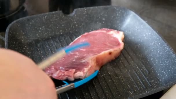 Qualcuno frigge una bistecca su una padella, chiudi. — Video Stock