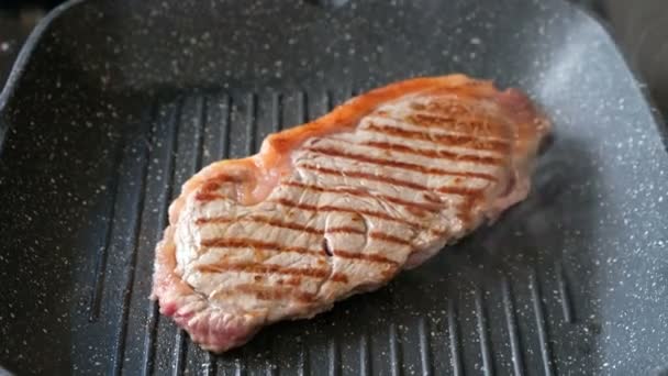 Somebody frying beefsteak on a grill pan, close up — Stock Video