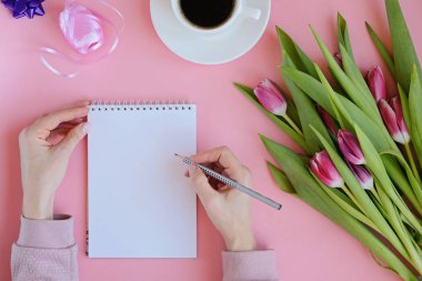 Pembe Lale çiçek, defter, fincan kahve ve akıllı telefonu ile kadınsı flatlay tarz