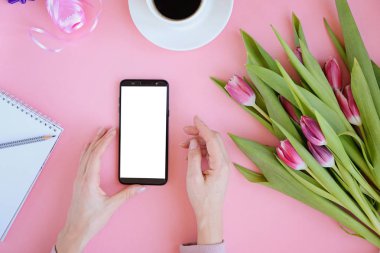 Pembe Lale çiçek, defter, fincan kahve ve akıllı telefonu ile kadınsı flatlay tarz