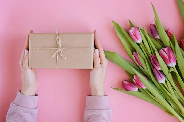 Plato femenino de estilo con flores de tulipán rosa y regalo en papel artesanal — Foto de Stock