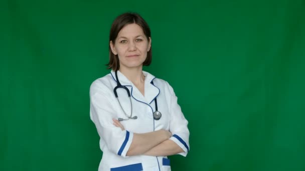 Mujer sonriente y confiada doctora en bata de laboratorio mirando la cámara en una pantalla verde, Chroma Key . — Vídeo de stock