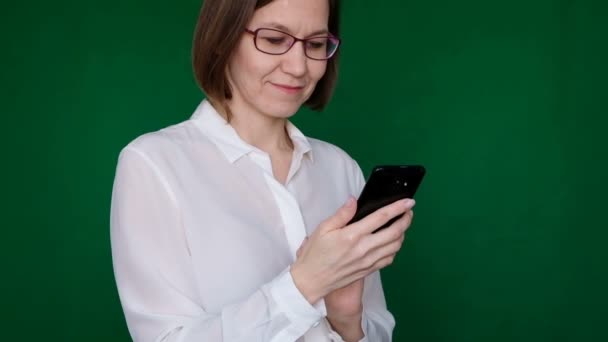 Žena pracující s smartphone na zeleném pozadí. Chromatický klíč. Detailní záběr — Stock video