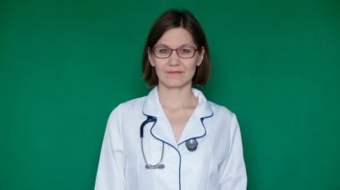 Kameraya bir yeşil ekranda Chroma Key arıyorsunuz laboratuar önlüğünü gülümseyen kendine güvenen kadın doktor. Yakın çekim
