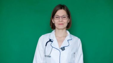 Kameraya bir yeşil ekranda Chroma Key arıyorsunuz laboratuar önlüğünü gülümseyen kendine güvenen kadın doktor. Yakın çekim