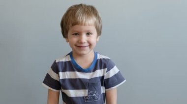 Kameraya bakarak ve gülümseyen küçük çocuk