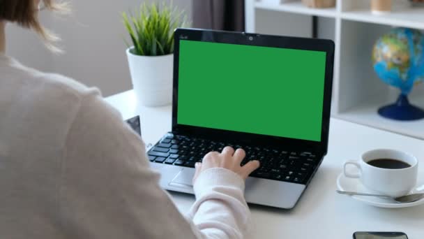 Mujer trabajando en una computadora, pantalla verde. Sobre el hombro disparado — Vídeo de stock