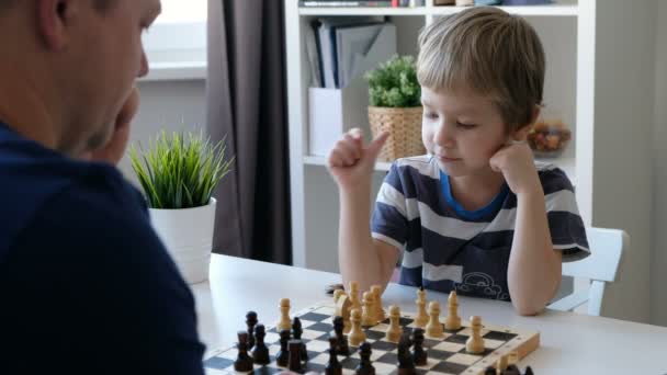 小さな男の子は、父親とチェスします。教育と家族の概念 — ストック動画