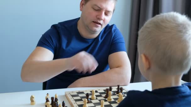 Petit garçon jouant aux échecs avec son père. Éducation et concept familial — Video